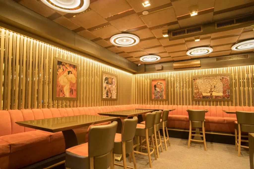 Салонът на BLEND Bar & Dinner със златни ламели и картини в стил Климт